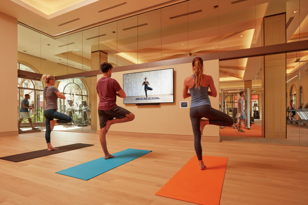 People doing yoga stance in apartment studio room