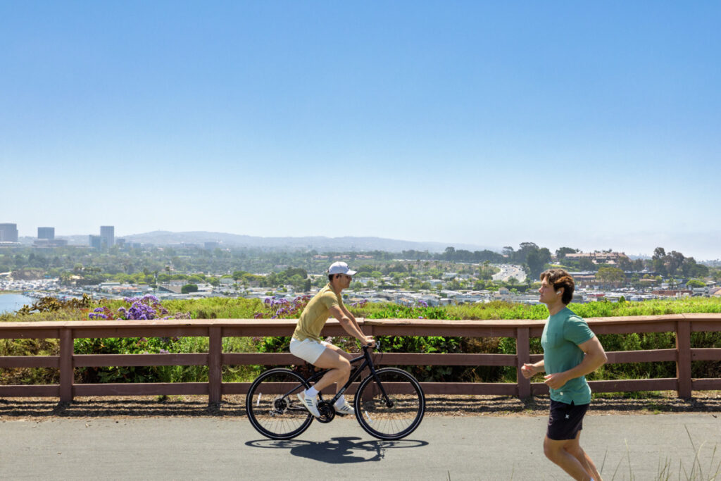 Exterior view of biker and runner outdoors at Newport Beach